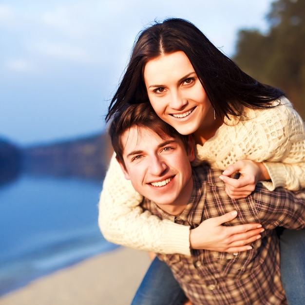 Primer plano de hombre contento llevando a su novia en la espalda