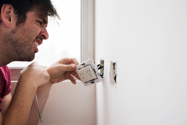 Primer plano de hombre electricista trabajando en casa