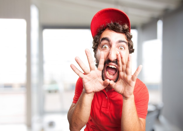 Primer plano de hombre enfadado con gorra roja gritando