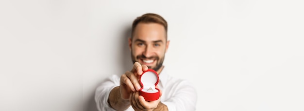 Foto gratuita el primer plano de un hombre guapo que pide casarse con él se centra en la caja con el concepto de anillo de bodas de propuesta y r