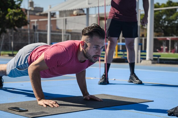 Primer plano de un hombre haciendo ejercicio con su entrenador