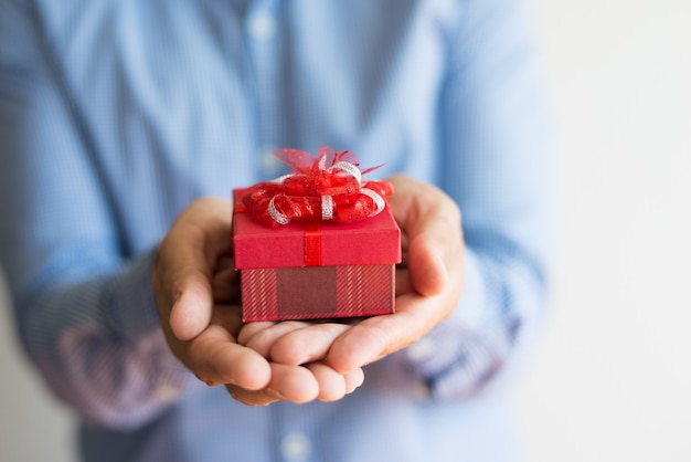 Foto gratuita primer plano de hombre irreconocible con pequeños regalos en las manos