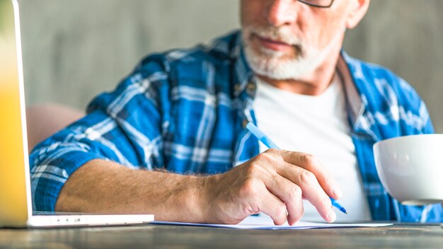 Primer plano, de, hombre mayor, mirar, computadora portátil, nota