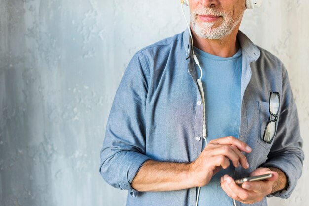 Foto gratuita primer plano, de, hombre mayor, tenencia, teléfono móvil