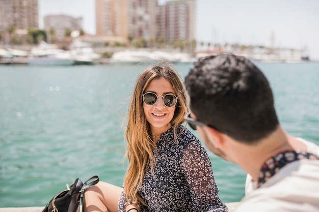 Foto gratuita primer plano de hombre mirando sonriente joven mujer llevaba gafas de sol