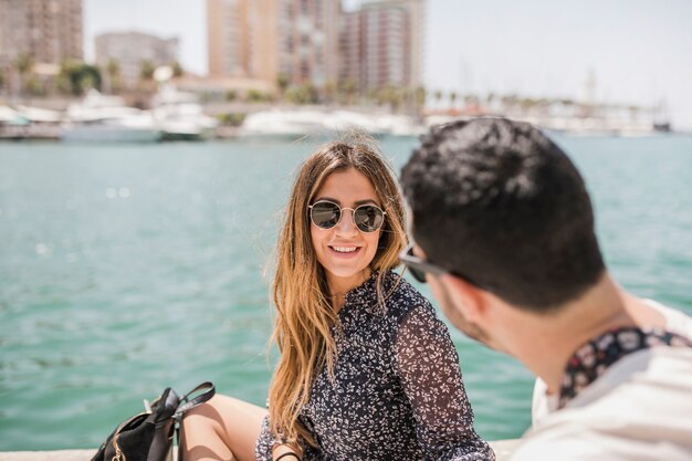 Primer plano de hombre mirando sonriente joven mujer llevaba gafas de sol