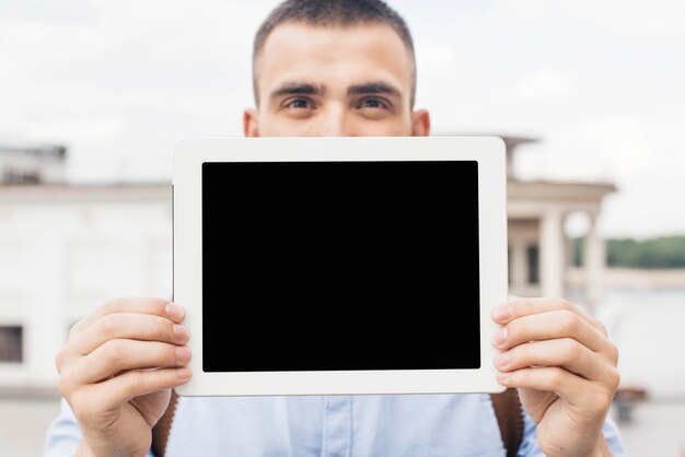 Primer plano del hombre mostrando tableta digital al aire libre