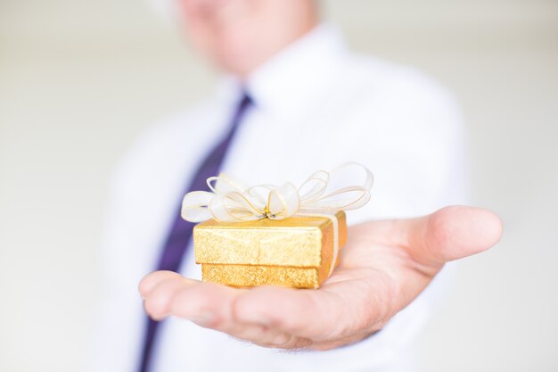 Primer plano de hombre de negocios dando caja de regalo pequeña
