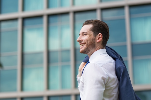 Primer plano de hombre de negocios feliz de pie fuera