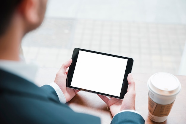 Primer plano de un hombre de negocios mirando tableta digital con pantalla en blanco en caf�