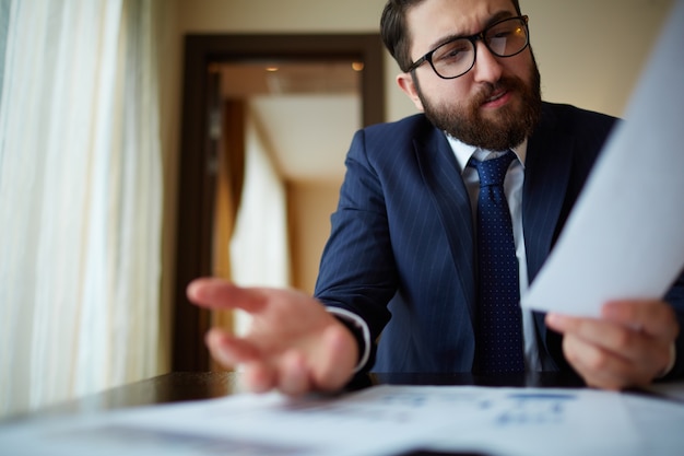 Primer plano de hombre de negocios sujetando un papel en su oficina