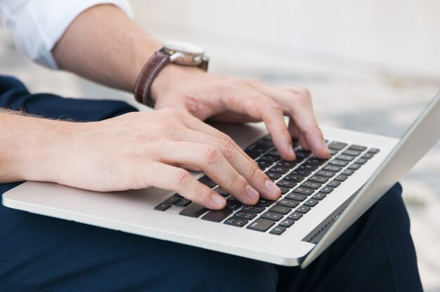 Primer plano de hombre de negocios trabajando en la computadora portátil al aire libre