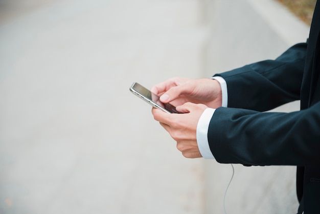 Primer plano, de, hombre de negocios, utilizar, teléfono móvil