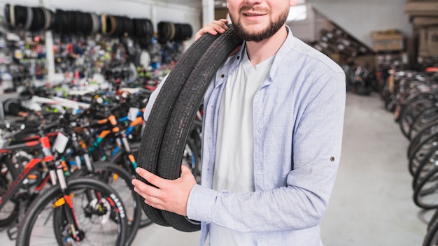 Primer plano de un hombre con neumáticos de bicicleta en la tienda