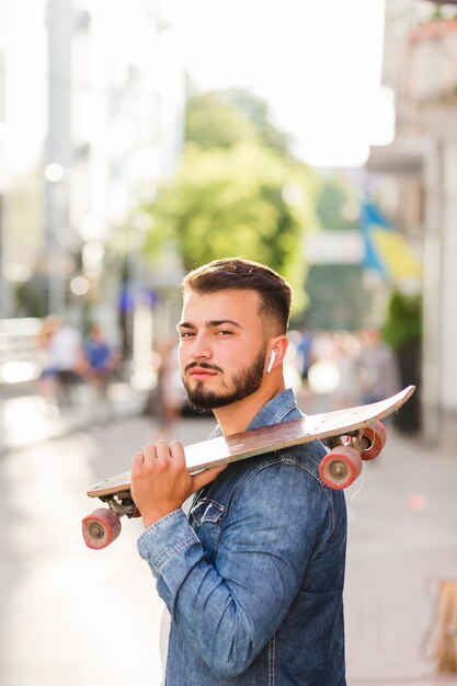 Primer plano de un hombre con patín mirando a cámara