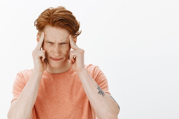 Primer plano de hombre pelirrojo de aspecto serio enfocado tratando de concentrarse