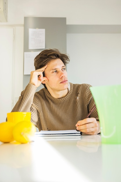 Primer plano de un hombre pensando qué escribir