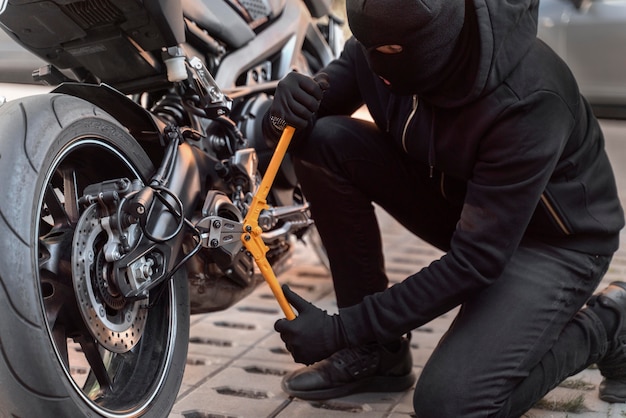 Primer plano del hombre preparándose para robar una motocicleta