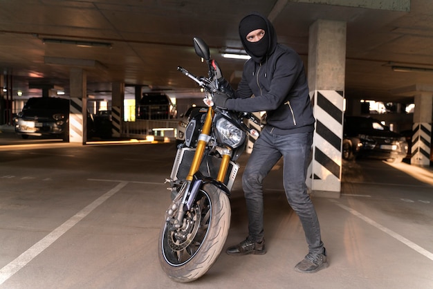 Primer plano del hombre preparándose para robar una motocicleta