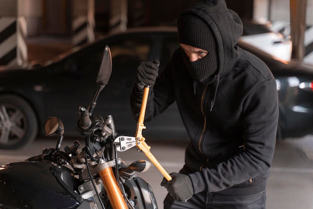 Primer plano del hombre preparándose para robar una motocicleta