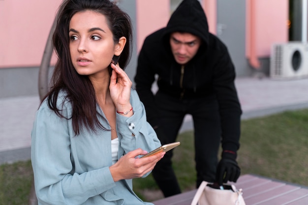 Primer plano del hombre preparándose para robar a la mujer joven