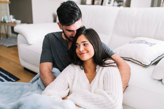 Primer plano del hombre que ama a su novia sentada cerca del sofá