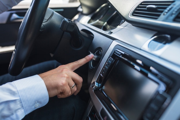 Foto gratuita primer plano de un hombre que inserta la llave para arrancar el automóvil