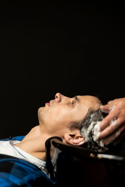 Primer plano del hombre que se lava el cabello con espacio de copia