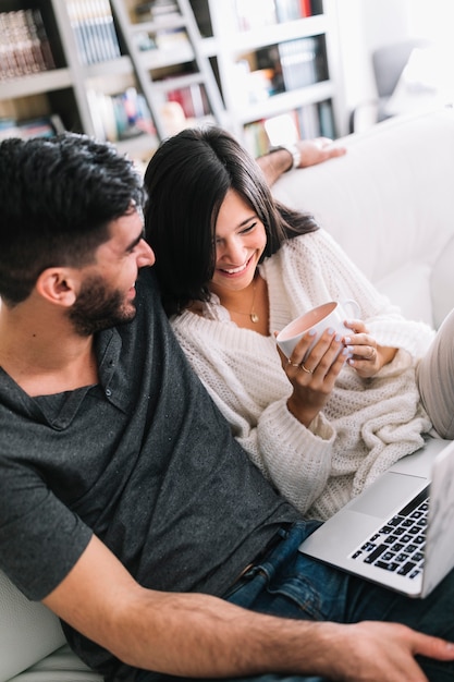 Primer plano, de, hombre que mira, sonriente, mujer, tenencia, taza de café