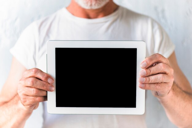 Primer plano de un hombre que muestra la pantalla de la tableta digital