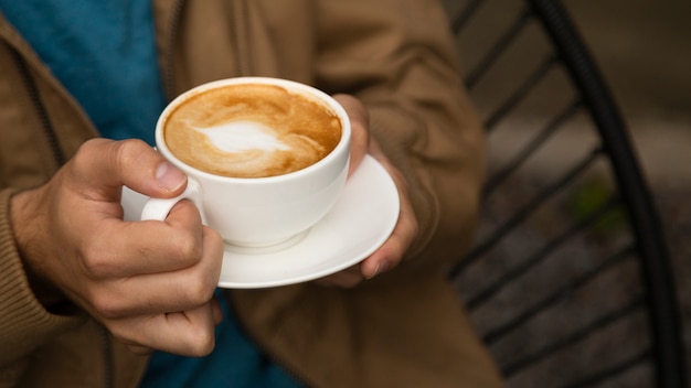 Primer plano del hombre que sostiene la taza de café