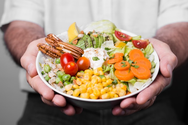 Primer plano del hombre que sostiene un tazón de comida saludable