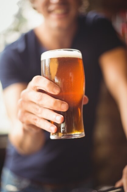 Primer plano del hombre que sostiene un vaso de cerveza