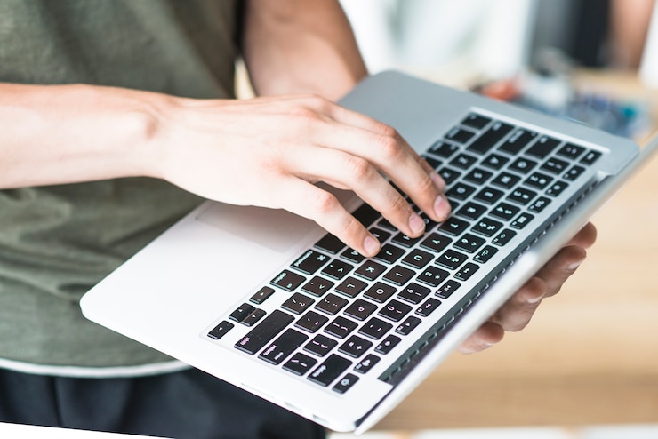 Foto gratuito primer plano del hombre que usa el teclado de la computadora portátil