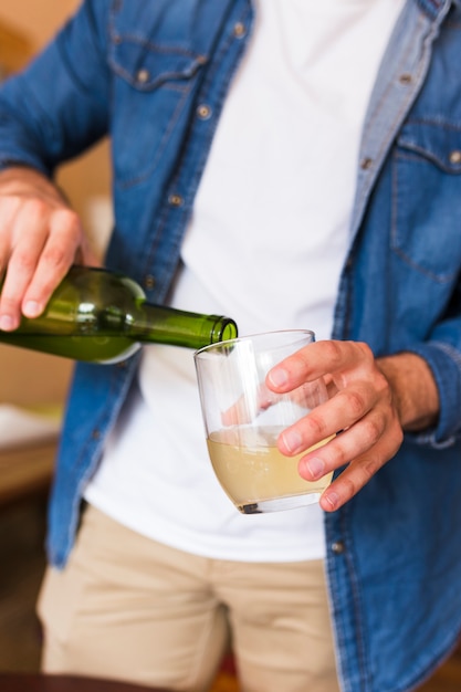 Primer plano de un hombre que vierte cerveza en vidrio