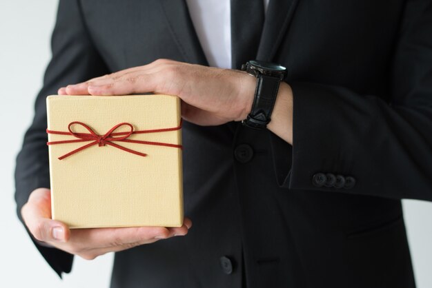 Primer plano de hombre con reloj de pulsera con caja de regalo