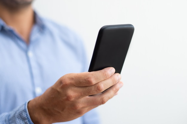 Primer plano de hombre sosteniendo y navegando en smartphone