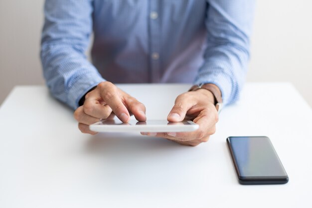 Primer plano de hombre trabajando y tocando en tablet PC