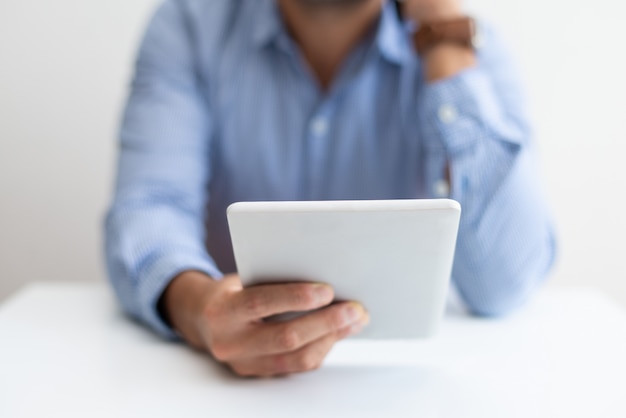 Primer plano de hombre trabajando, usando tableta y llamando al teléfono