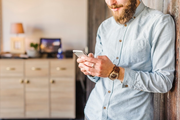 Foto gratuita primer plano, de, un, hombre, utilizar, teléfono móvil