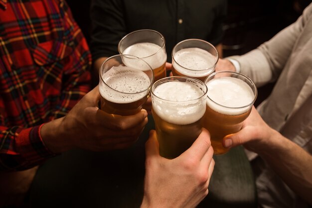 Primer plano de hombres brindando con cerveza