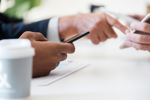 Primer plano de hombres de negocios usando teléfono móvil