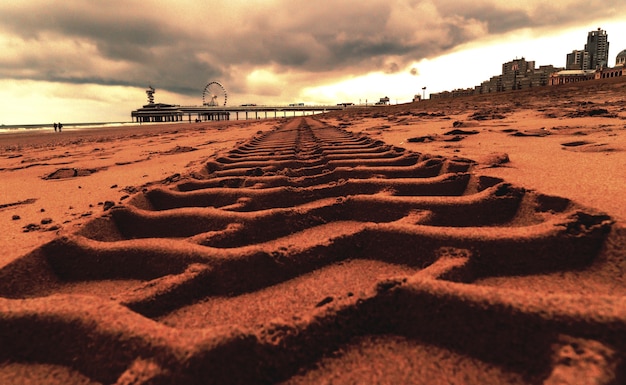 Primer plano de huellas de neumáticos en la arena en el muelle de Scheveningen en La Haya