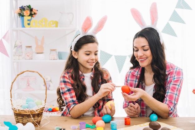 Primer plano de los huevos para colorear de niña y madre para Pascua en casa