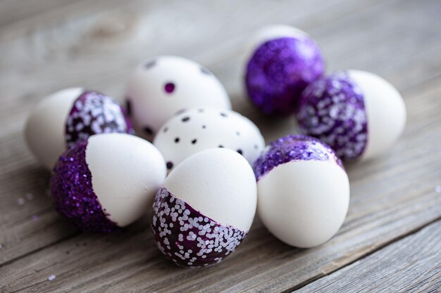 Primer plano de huevos de pascua decorados con destellos púrpuras