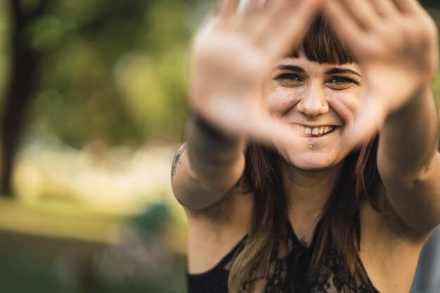 Primer plano de una joven atractiva mujer caucásica con tatuajes haciendo una linda cara