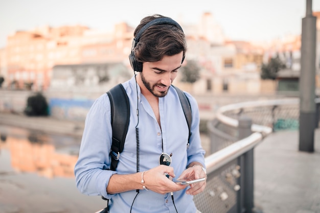 Primer plano de un joven escuchando música en el teléfono inteligente