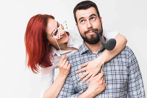 Primer plano de una joven pareja con accesorios para fiestas