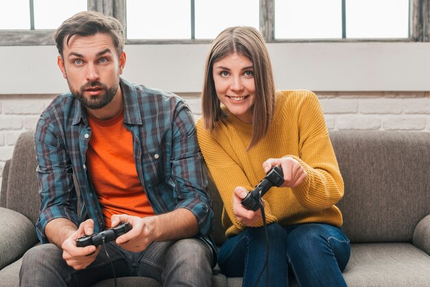 Primer plano de la joven pareja jugando al videojuego con joystick