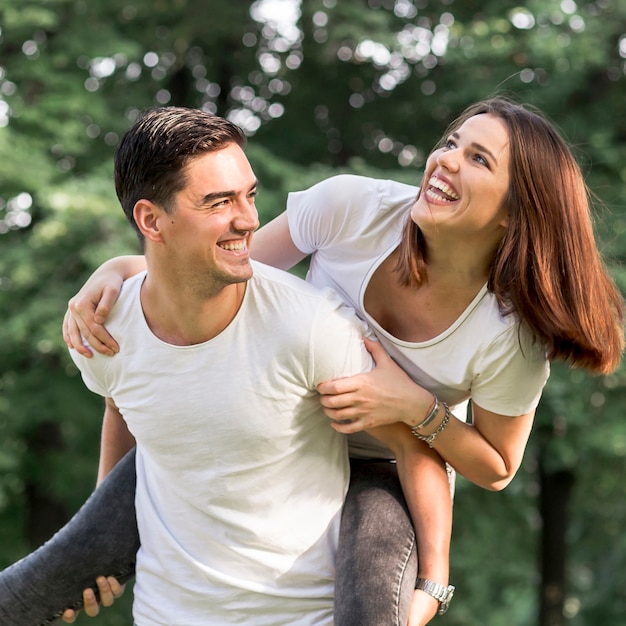 Primer plano de un joven que lleva a su novia sonriente